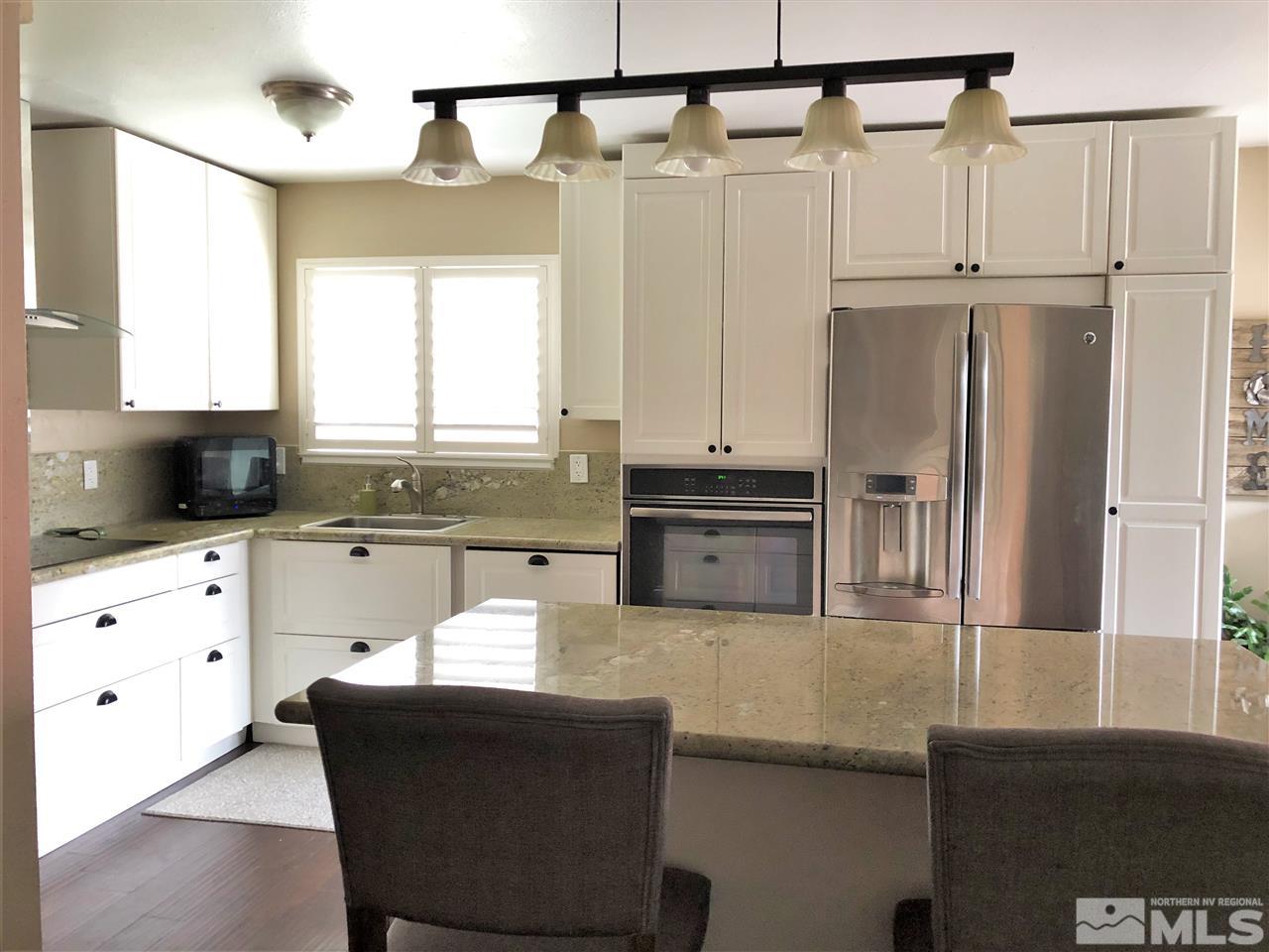 1785 Ada's Street Reno, NV 89509 - Photo 3 of 19 a kitchen with kitchen island white cabinets and refrigerator