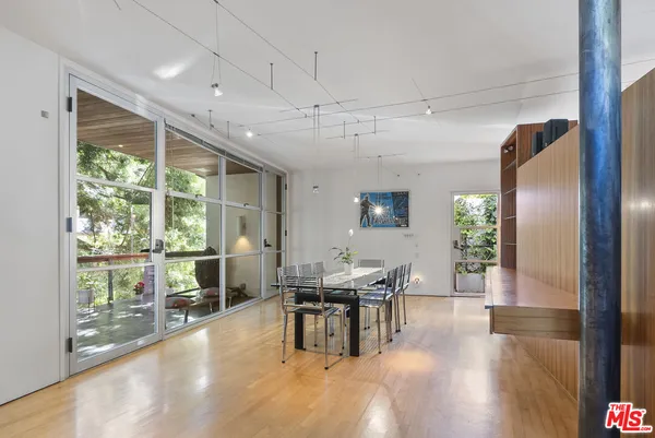 a dining hall with couches a dining table and chairs with outer view