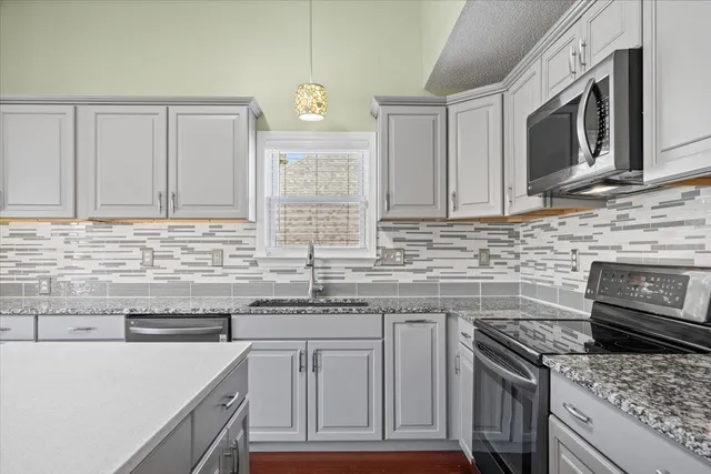 a kitchen with stainless steel appliances granite countertop a sink stove and microwave