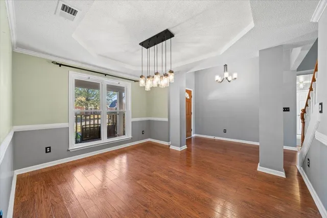a view of a livingroom with a chandelier fan and wooden floor