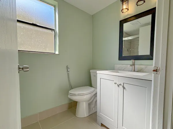 a bathroom with a toilet sink and mirror