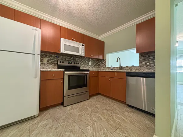 a kitchen with stainless steel appliances granite countertop a stove a sink and a refrigerator