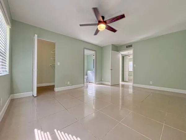 an empty room with closet and chandelier fan