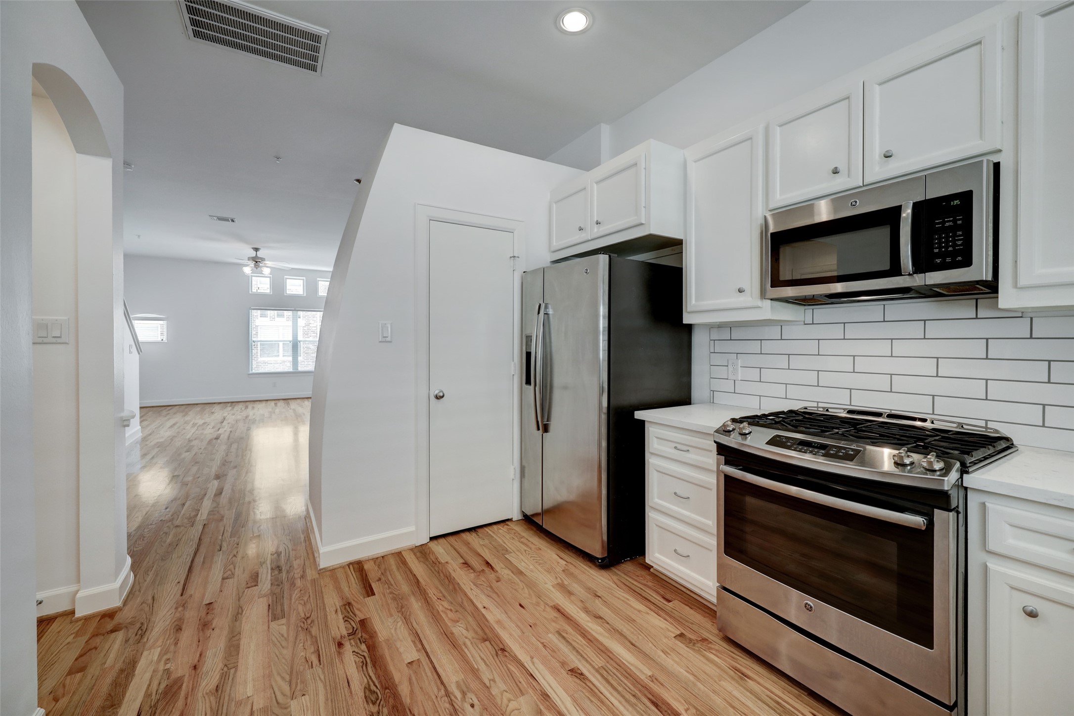 5941 South Loop E Freeway, Unit 1002 Houston, TX 77033 - Photo 9 of 16 a kitchen with white cabinets stainless steel appliances and wooden floor