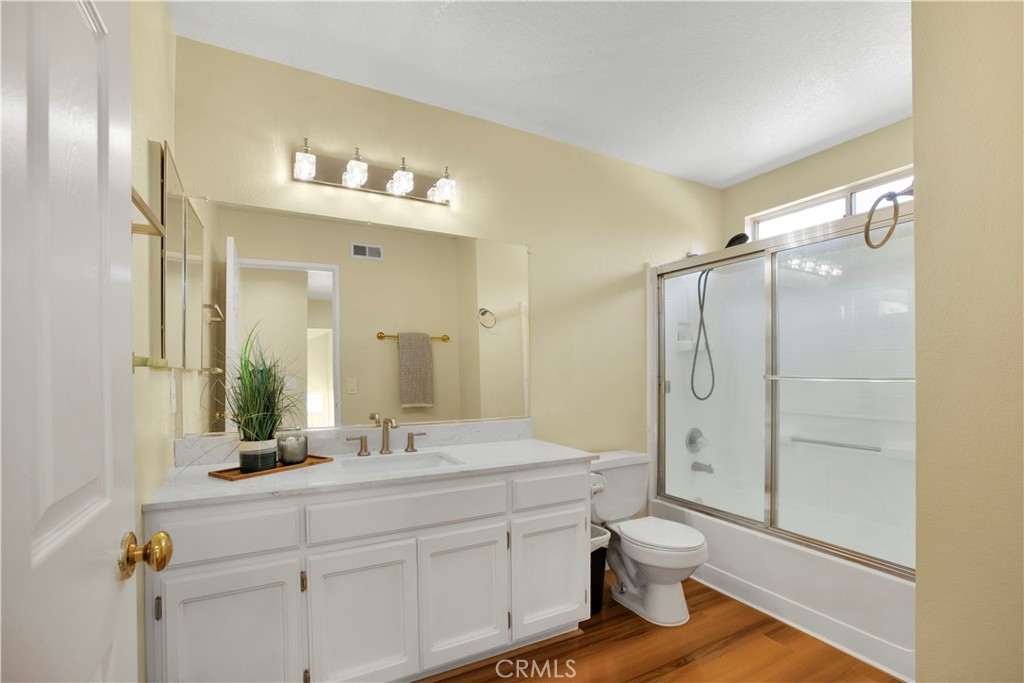 22705 Robin Way Grand Terrace, CA 92313 - Photo 7 of 15 a bathroom with a double vanity sink toilet mirror and shower
