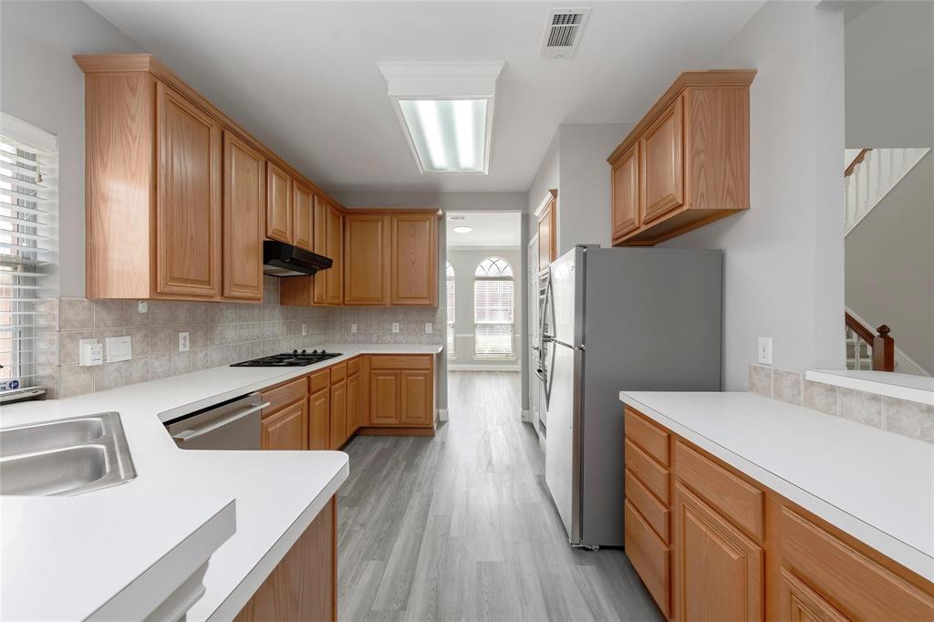 2313 Hunters Run Drive Plano, TX 75025 - Photo 11 of 36 a kitchen with granite countertop a sink a counter space appliances and cabinets