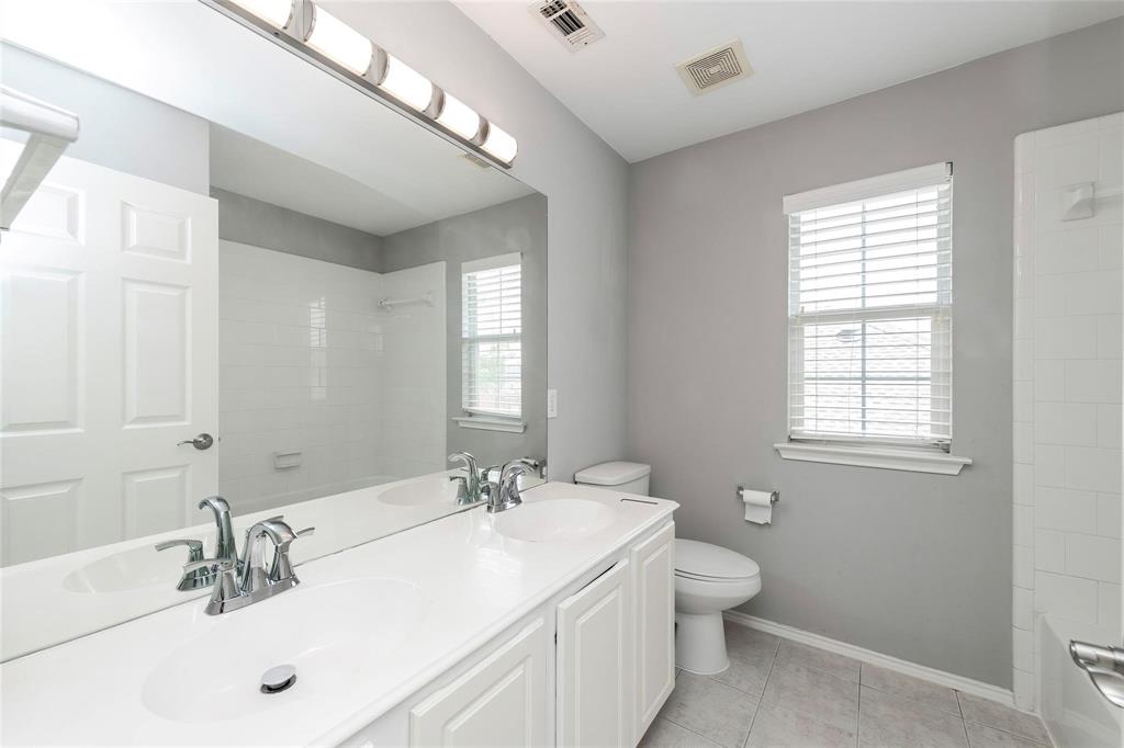 2313 Hunters Run Drive Plano, TX 75025 - Photo 32 of 36 a bathroom with a toilet a sink a mirror and a window