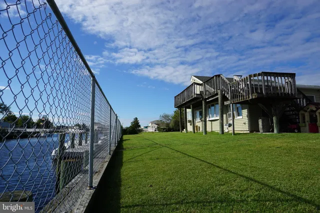 a view of a big house with a big yard and large trees