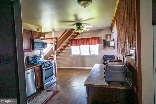 a view of a livingroom with furniture stairs windows and wooden floor