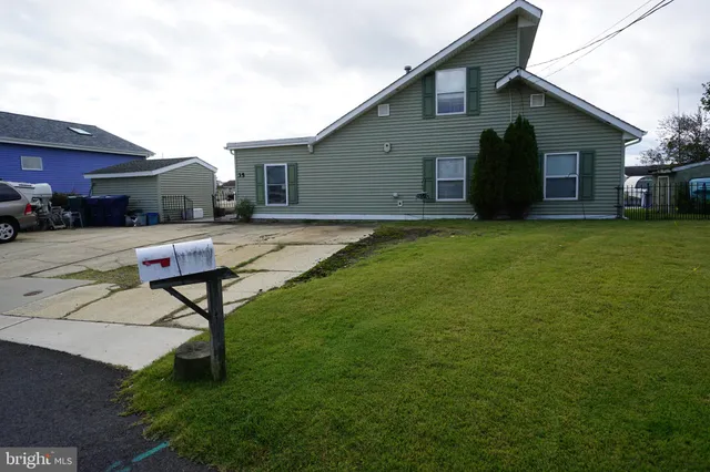 a house view with a sitting space fire pit and outdoor space