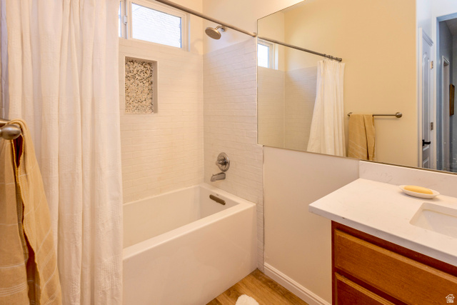 11751 Lake Run Road South Jordan, UT 84009 - Photo 18 of 38 Bathroom featuring a white bathtub, tiled shower surround with an integrated niche, and a vanity with a white countertop and wood-finish cabinetry