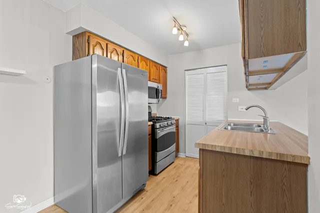 a kitchen with stainless steel appliances granite countertop a sink and a refrigerator