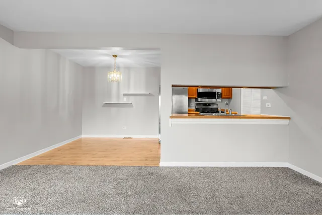 a view of kitchen and empty room with cabinet