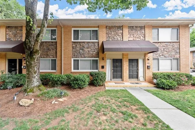 a front view of a brick house with a yard