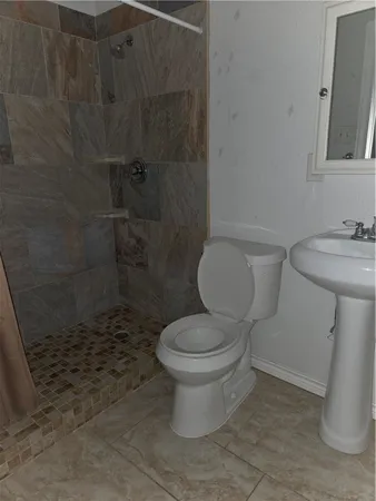 a white toilet sitting next to a bathroom sink