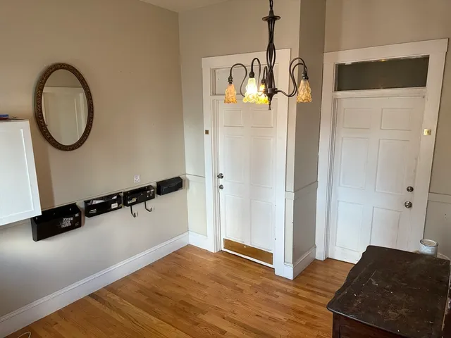 a view of a room with wooden floor and white walls