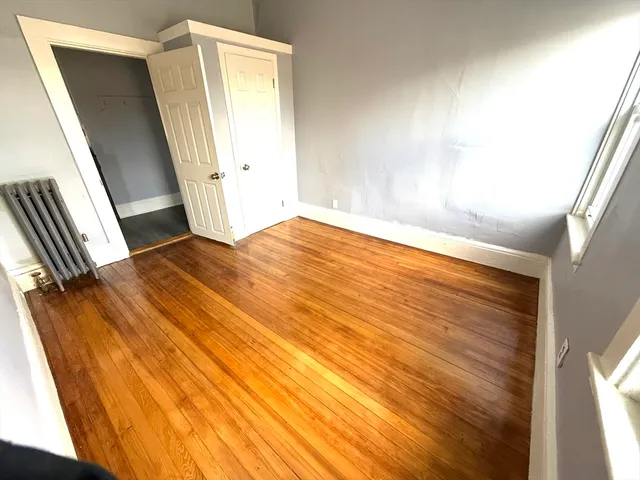 a view of a big room with wooden floor and windows