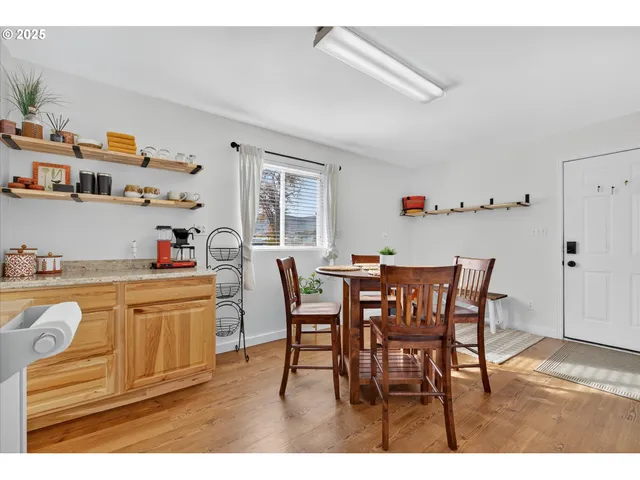 a kitchen with stainless steel appliances granite countertop a dining table and chairs