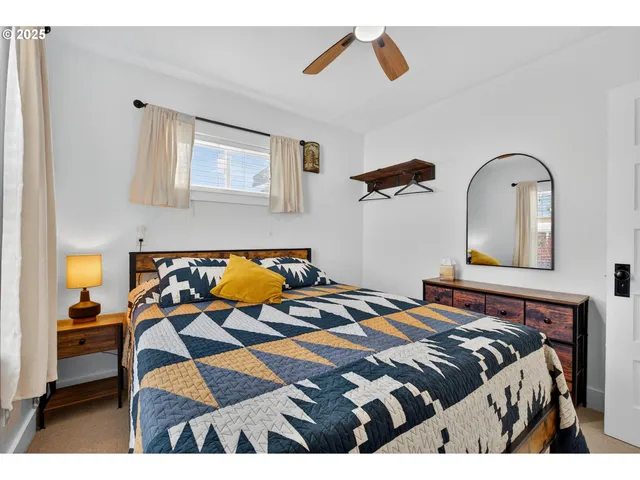 a bedroom with a bed and painting on the wall