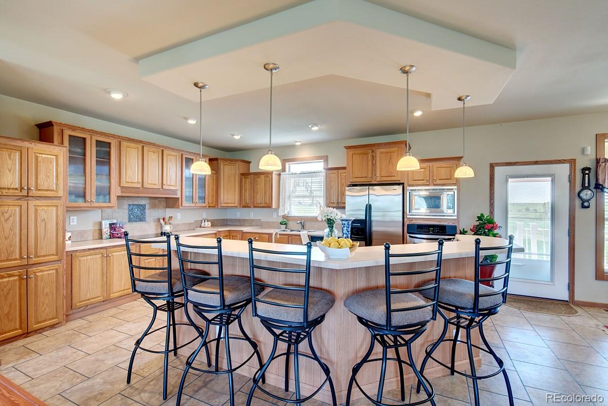 18045 Jones Road Peyton, CO 80831 - Photo 8 of 35 a dining room with stainless steel appliances kitchen island a table and chairs