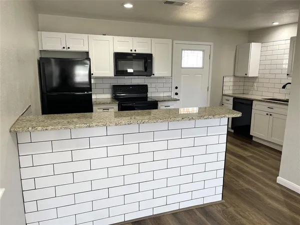 a kitchen with stainless steel appliances a sink a stove a microwave and cabinets