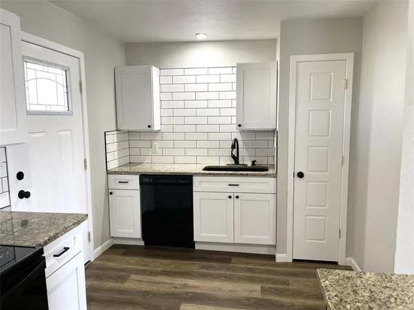 a kitchen with granite countertop a sink and a stove
