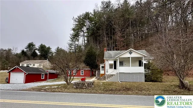 a view of a white house with a sink and yard next to a road