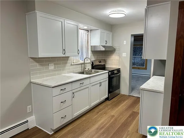 a kitchen with granite countertop white cabinets and white appliances