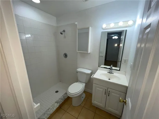 a bathroom with a toilet a sink a vanity and mirror