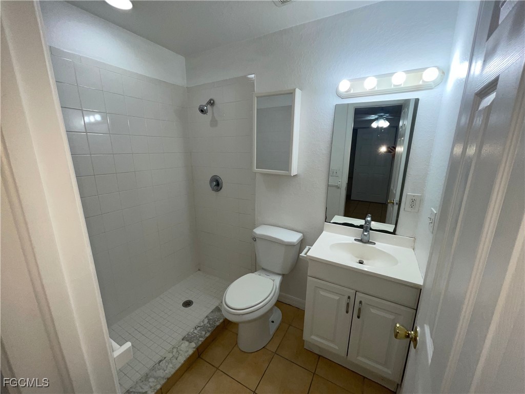 361 Bell Boulevard Lehigh Acres, FL 33974 - Photo 9 of 10 a bathroom with a toilet a sink a vanity and mirror