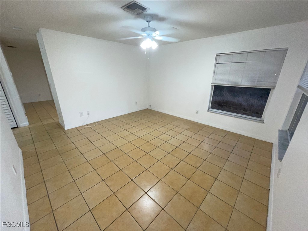361 Bell Boulevard Lehigh Acres, FL 33974 - Photo 10 of 10 en empty room with a fireplace and a chandelier fan