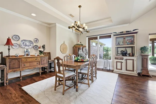 a kitchen filled with white cabinets and chandelier