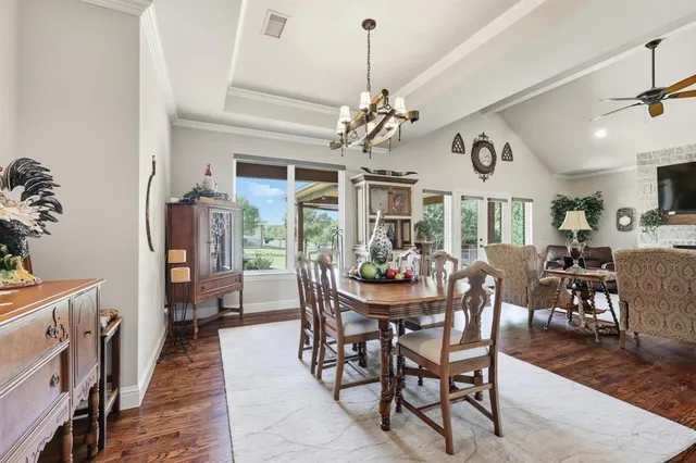 a view of a dining room with furniture a chandelier and wooden floor