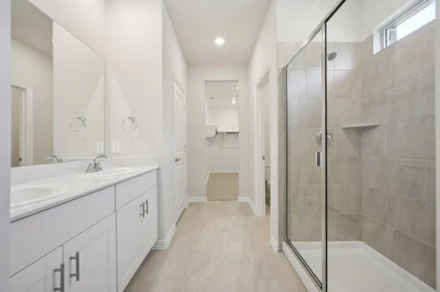 a bathroom with a double vanity sink and mirror with shower