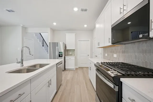 a kitchen that has a sink and a stove top oven