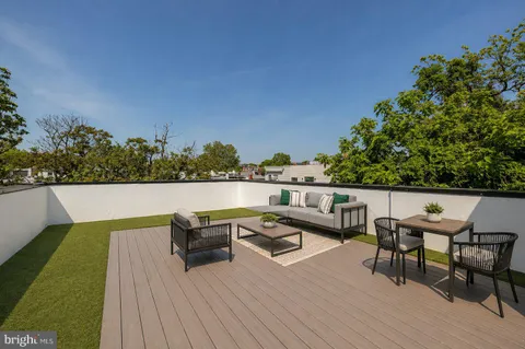 a balcony with wooden floor table and chairs