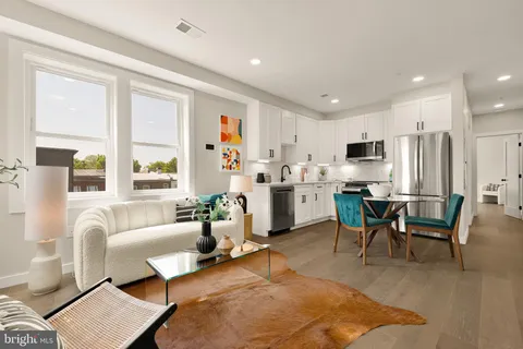 a living room with furniture and kitchen view