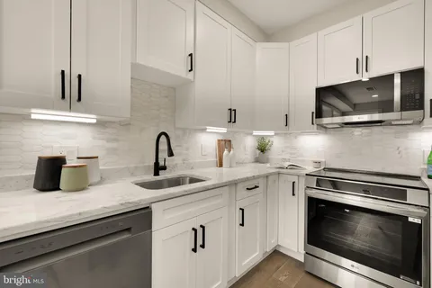 a kitchen with sink a microwave and cabinets