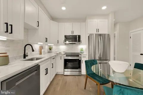 a kitchen with stainless steel appliances a stove a sink a microwave a refrigerator and cabinets