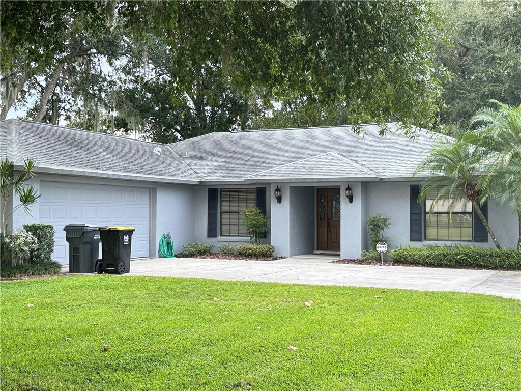 a front view of a house with a garden and plants