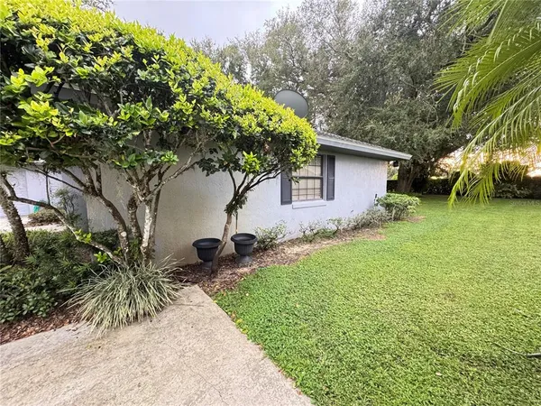 a backyard of a house with table and chairs under an umbrella