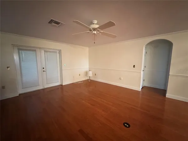 a kitchen with stainless steel appliances kitchen island granite countertop wooden floors and white cabinets