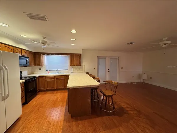 a kitchen with granite countertop wooden cabinets stove top oven and sink