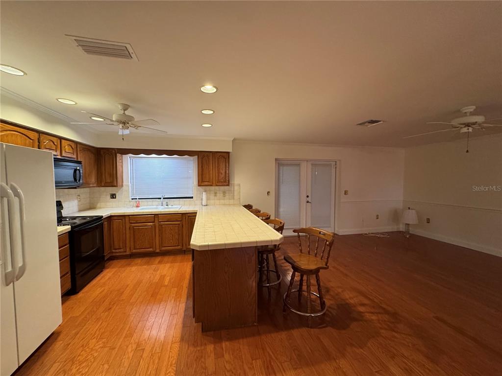 10 Fort Clinch Heights Road Frostproof, FL 33843 - Photo 25 of 40 a kitchen with stainless steel appliances kitchen island granite countertop wooden floors and white cabinets