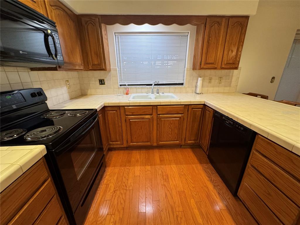 10 Fort Clinch Heights Road Frostproof, FL 33843 - Photo 26 of 40 a kitchen with granite countertop wooden cabinets stove top oven and sink