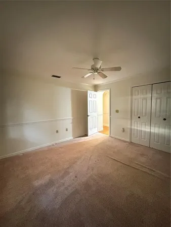 an empty room with a ceiling fan and window