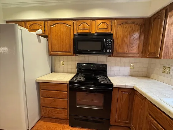 a kitchen with granite countertop a stove and a microwave