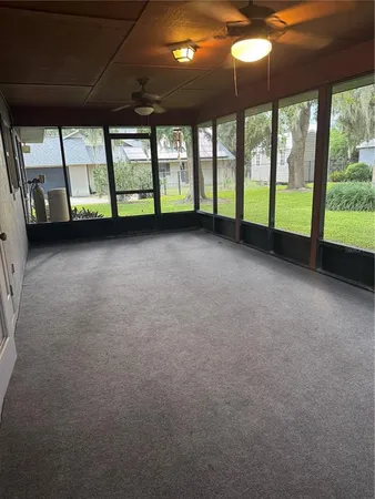 a view of empty room with kitchen