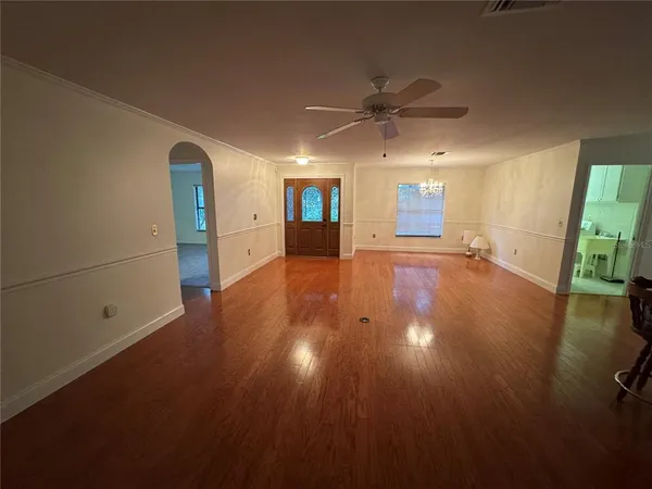 a view of a livingroom with wooden floor and a ceiling fan