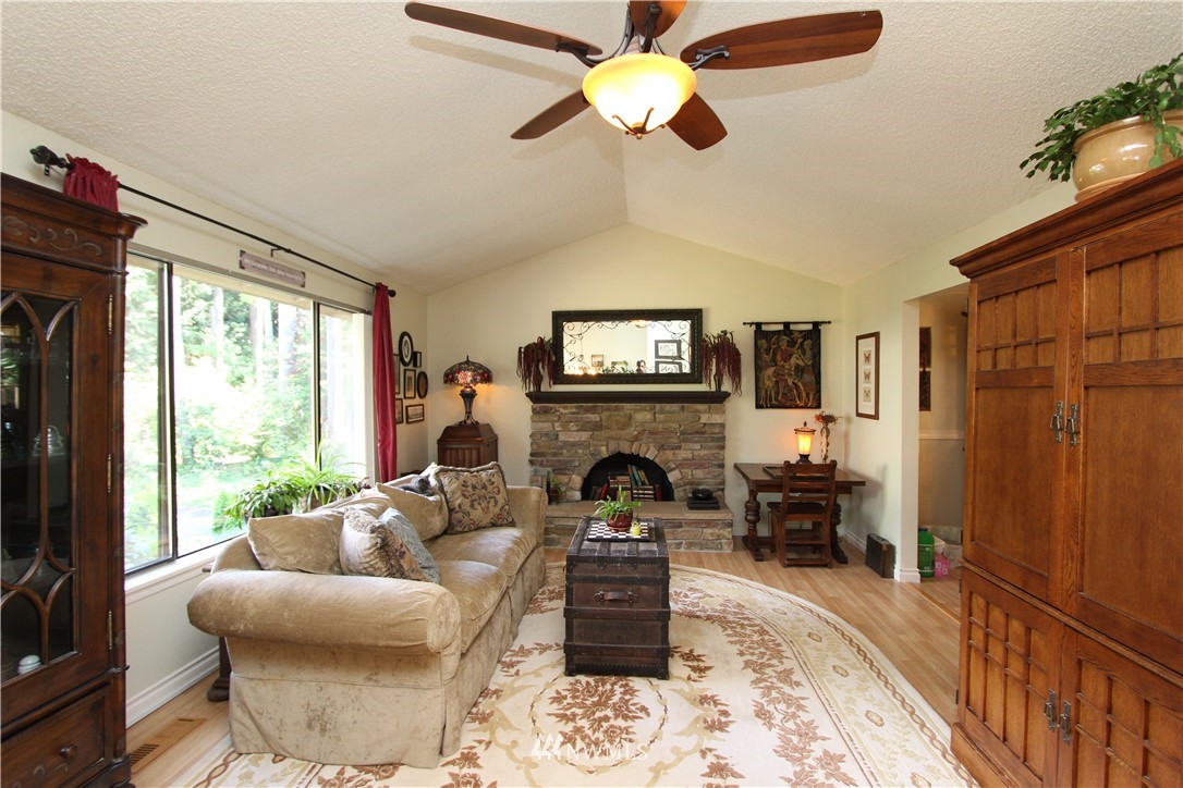 320 170th Place Southwest Bothell, WA 98012 - Photo 2 of 25 a living room with furniture a fireplace and a flat screen tv